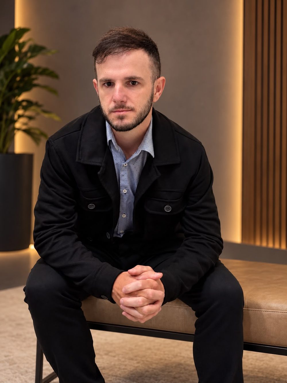 Alisson Pereira, psicólogo, sentado na recepção do consultório